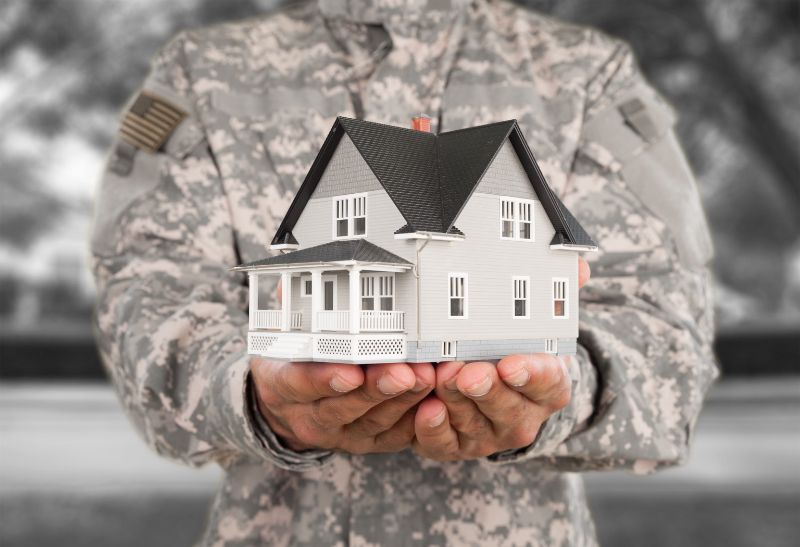 a man in military uniform holding a mini model house