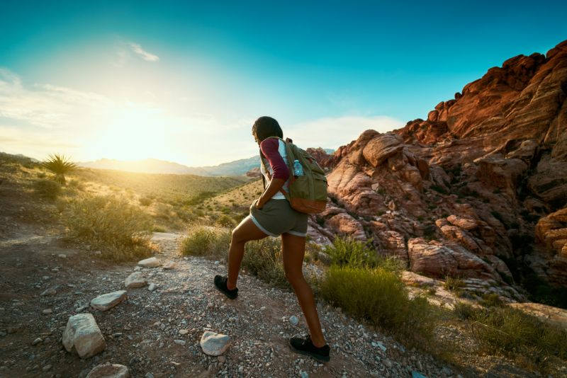 Woman backpacker hiking at Red Rock Canyon during sunrise