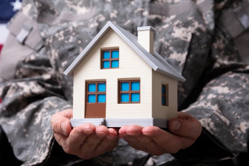 A soldier holding a house model