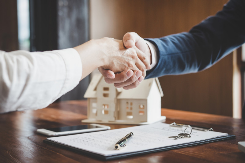 Real estate agent and their client shaking hands
